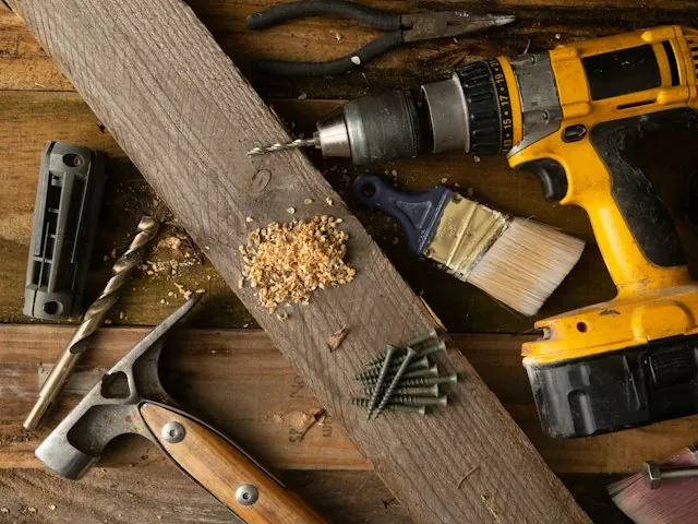 a cordless drill and tools on a workbench