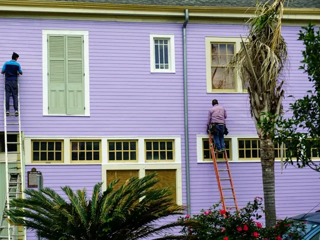 house painters on ladders painting a home exterior